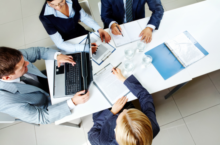 Home buyers and real estate professionals reviewing documents during a home purchase negotiation