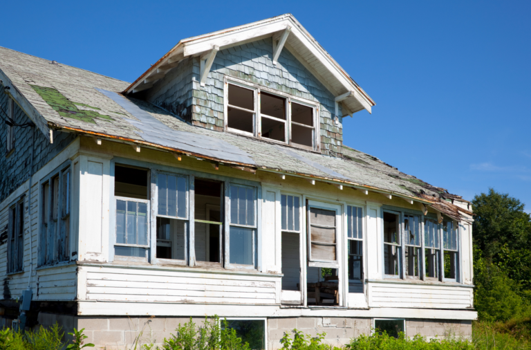 Older home with visible exterior deterioration and deferred maintenance